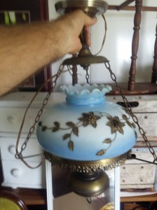 Antique brass chandelier with blue glass globe retrieved from a hundred year old home